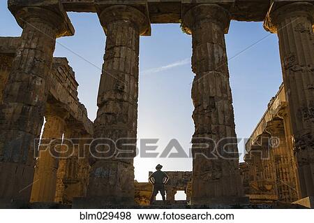 Stock Photo - Caucasian man standing in Temple at Selinunte ruins, Selinunte, Sicily, Italy. Fotosearch