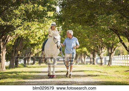 Caucasian man walking horse with granddaughter View Large Photo Image Stock Photo - Caucasian man walking horse with granddaughter. Fotosearch
