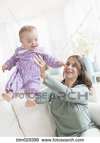 Caucasian mother playing with baby with Down Syndrome View Large Photo Image Stock Photo - Caucasian mother playing with baby with Down Syndrome. Fotosearch