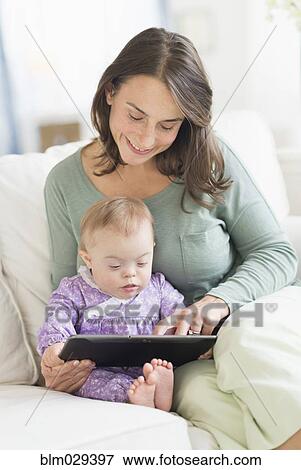 Caucasian mother reading to baby with Down Syndrome View Large Photo Image Stock Photo - Caucasian mother reading to baby with Down Syndrome. Fotosearch