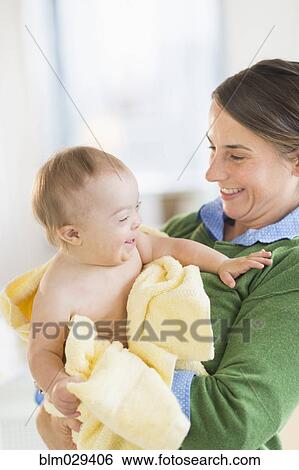Stock Photograph - Caucasian mother toweling baby girl with Down Syndrome. Fotosearch