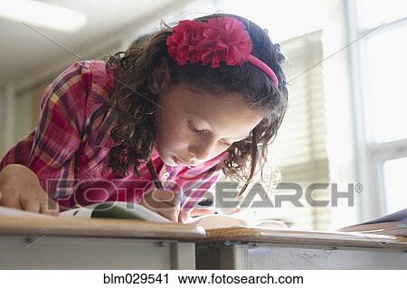 Stock Image - Caucasian student working in class. Fotosearch