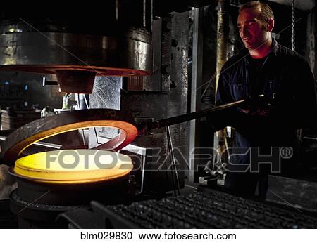 Stock Image - Caucasian worker melting steel in factory. Fotosearch