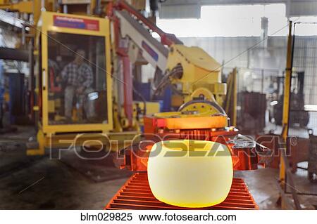 Stock Photography - Caucasian worker operating steel melting machinery in factory. Fotosearch