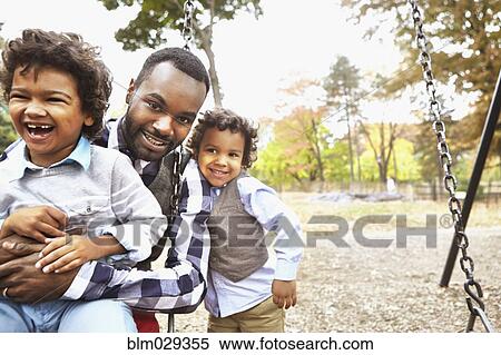 Father and sons playing together in park View Large Photo Image Stock Photography - Father and sons playing together in park. Fotosearch
