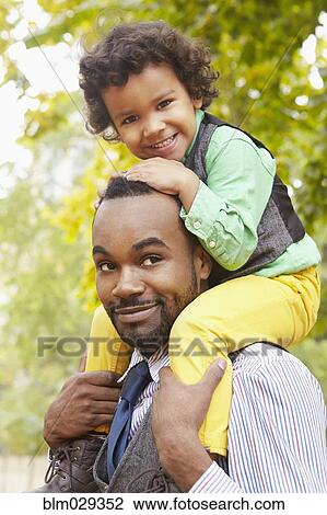Father carrying son in park View Large Photo Image Stock Image - Father carrying son in park. Fotosearch