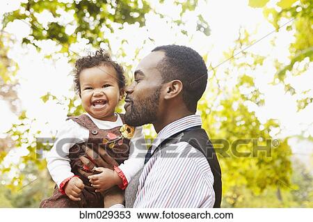 Father holding toddler daughter in park View Large Photo Image Stock Image - Father holding toddler daughter in park. Fotosearch