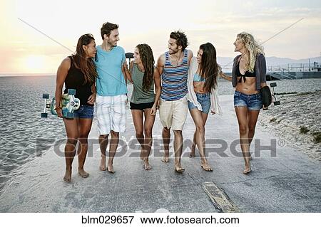 Friends walking together on beach View Large Photo Image Stock Photo - Friends walking together on beach. Fotosearch