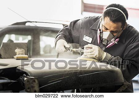 Stock Image - Hispanic mechanic working in auto shop. Fotosearch