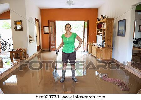 Hispanic woman shoveling water out of flooded house View Large Photo Image Stock Image - Hispanic woman shoveling water out of flooded house. Fotosearch