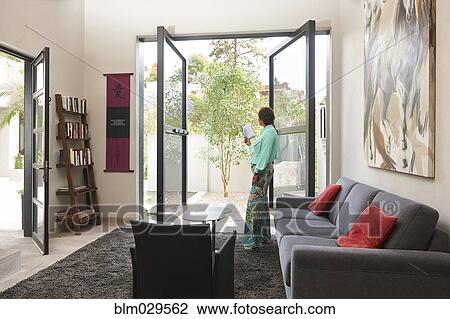 Hispanic woman standing at glass doors View Large Photo Image Stock Image - Hispanic woman standing at glass doors. Fotosearch