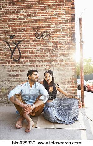 Indian couple sitting on city street View Large Photo Image Stock Image - Indian couple sitting on city street. Fotosearch