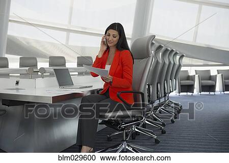 Mixed race businesswoman on cell phone in conference room View Large Photo Image Stock Image - Mixed race businesswoman on cell phone in conference room. Fotosearch
