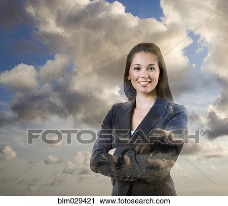 Mixed race businesswoman standing in clouds View Large Photo Image Stock Image - Mixed race businesswoman standing in clouds. Fotosearch