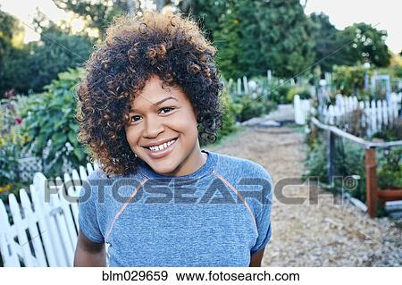 Stock Photo - Mixed race woman smiling in garden. Fotosearch