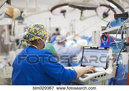Nurse using computer in operating room View Large Photo Image Stock Photo - Nurse using computer in operating room. Fotosearch