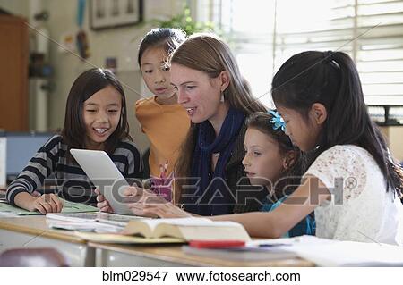 Stock Photo - Students and teacher using digital tablets in class. Fotosearch