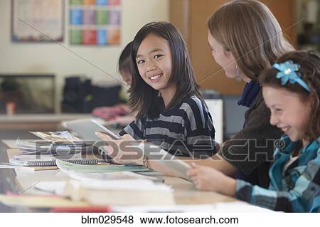 Stock Photo - Students and teacher using digital tablets in class. Fotosearch