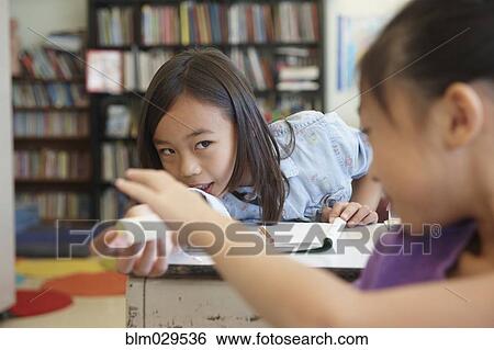 Stock Photograph - Students passing notes in class. Fotosearch