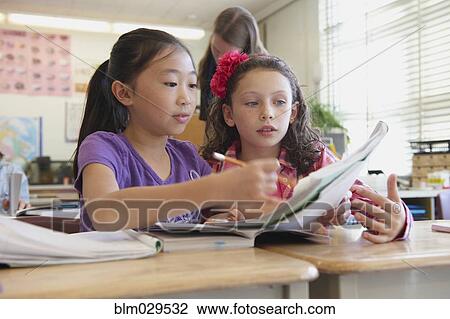 Stock Image - Students working together in class. Fotosearch