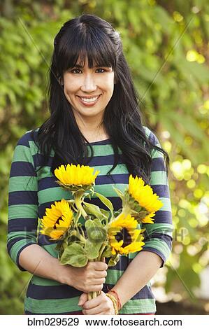 Stock Photo - Woman holding bouquet of sunflowers. Fotosearch