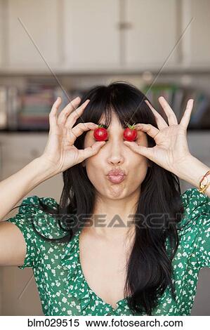 Stock Photography - Woman playing with tomatoes. Fotosearch