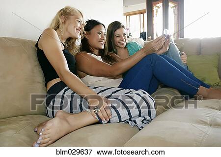 Women taking self-portrait together on sofa View Large Photo Image Stock Photo - Women taking self-portrait together on sofa. Fotosearch