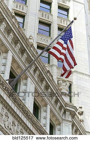 Stock Photo - American flag hanging from ornate building. Fotosearch
