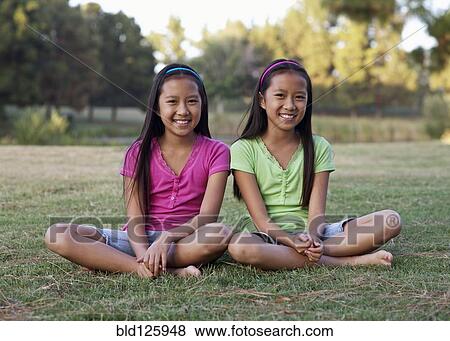 Asian twin girls smiling outdoors View Large Photo Image Stock Photo - Asian twin girls smiling outdoors. Fotosearch