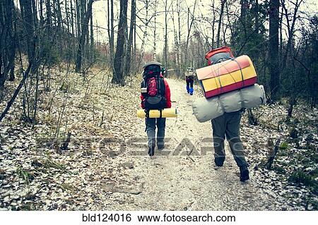 Stock Photograph - Backpackers walking in winter forest. Fotosearch