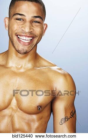 Stock Image - Bare chested mixed race man smiling. Fotosearch