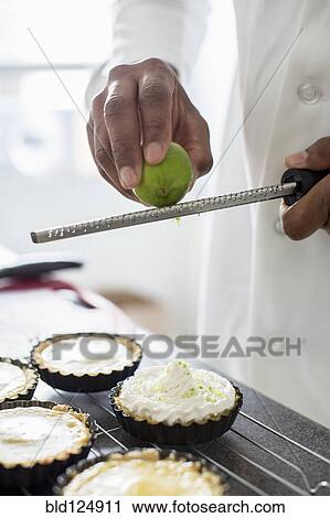 Stock Image - Black chef making key lime tart in restaurant. Fotosearch