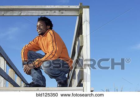 Black man on wooden dock outdoors View Large Photo Image Stock Image - Black man on wooden dock outdoors. Fotosearch