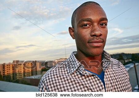 Black man standing on urban rooftop View Large Photo Image Stock Photo - Black man standing on urban rooftop. Fotosearch