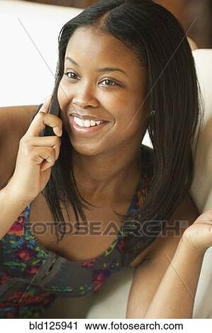Stock Image - Black woman talking on cell phone. Fotosearch