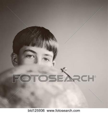 Boy peering over globe View Large Photo Image Stock Photograph - Boy peering over globe. Fotosearch