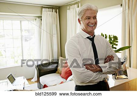 Stock Photo - Businessman smiling in living room. Fotosearch