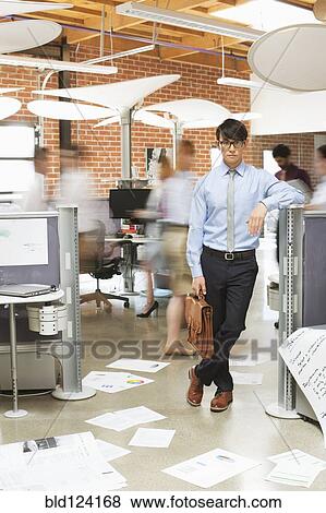 Stock Photo - Businessman standing in busy office. Fotosearch