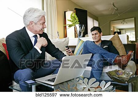 Stock Photo - Businessmen talking in living room. Fotosearch
