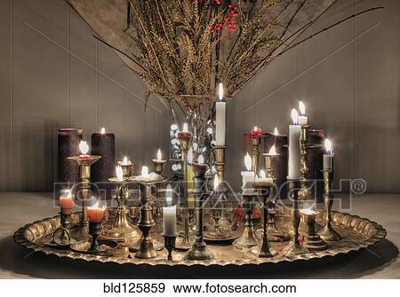 Stock Photo - Candles burning on metal platter. Fotosearch