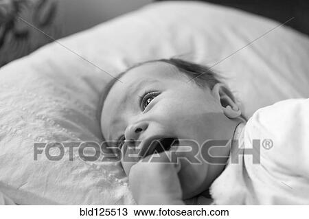 Stock Image - Caucasian baby boy laying on blanket. Fotosearch