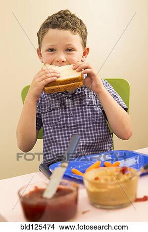 Caucasian boy eating sandwich in kitchen View Large Photo Image Picture - Caucasian boy eating sandwich in kitchen. Fotosearch