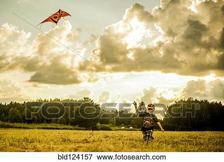 Caucasian boy flying kite in rural field View Large Photo Image Stock Photo - Caucasian boy flying kite in rural field. Fotosearch