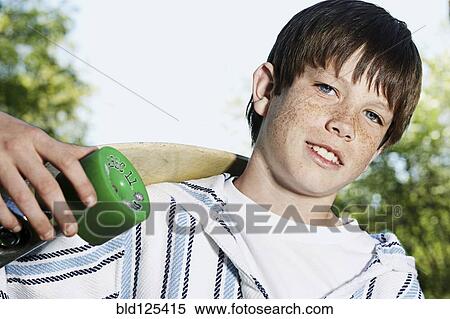 Caucasian boy holding skateboard outdoors View Large Photo Image Stock Photography - Caucasian boy holding skateboard outdoors. Fotosearch