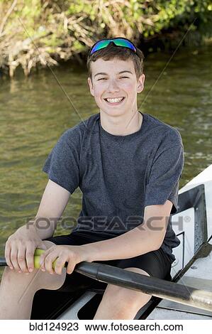 Stock Image - Caucasian boy smiling in kayak. Fotosearch
