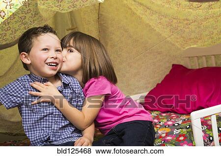 Caucasian children kissing in blanket fort View Large Photo Image Stock Photo - Caucasian children kissing in blanket fort. Fotosearch