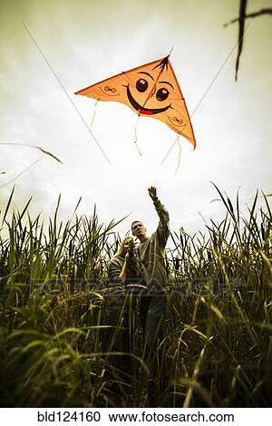 Caucasian couple flying kite in rural field View Large Photo Image Stock Image - Caucasian couple flying kite in rural field. Fotosearch