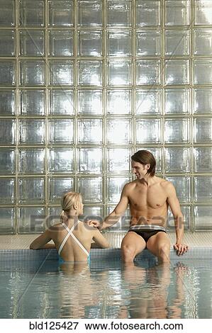 Stock Photo - Caucasian couple relaxing in pool. Fotosearch