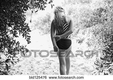 Caucasian girl in bathing suit walking on sandy path View Large Photo Image Stock Photograph - Caucasian girl in bathing suit walking on sandy path. Fotosearch