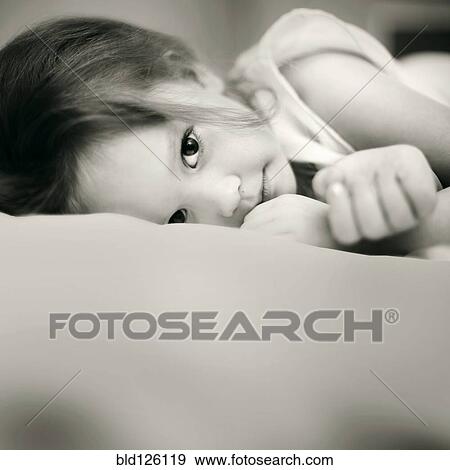 Caucasian girl laying on bed View Large Photo Image Stock Photo - Caucasian girl laying on bed. Fotosearch